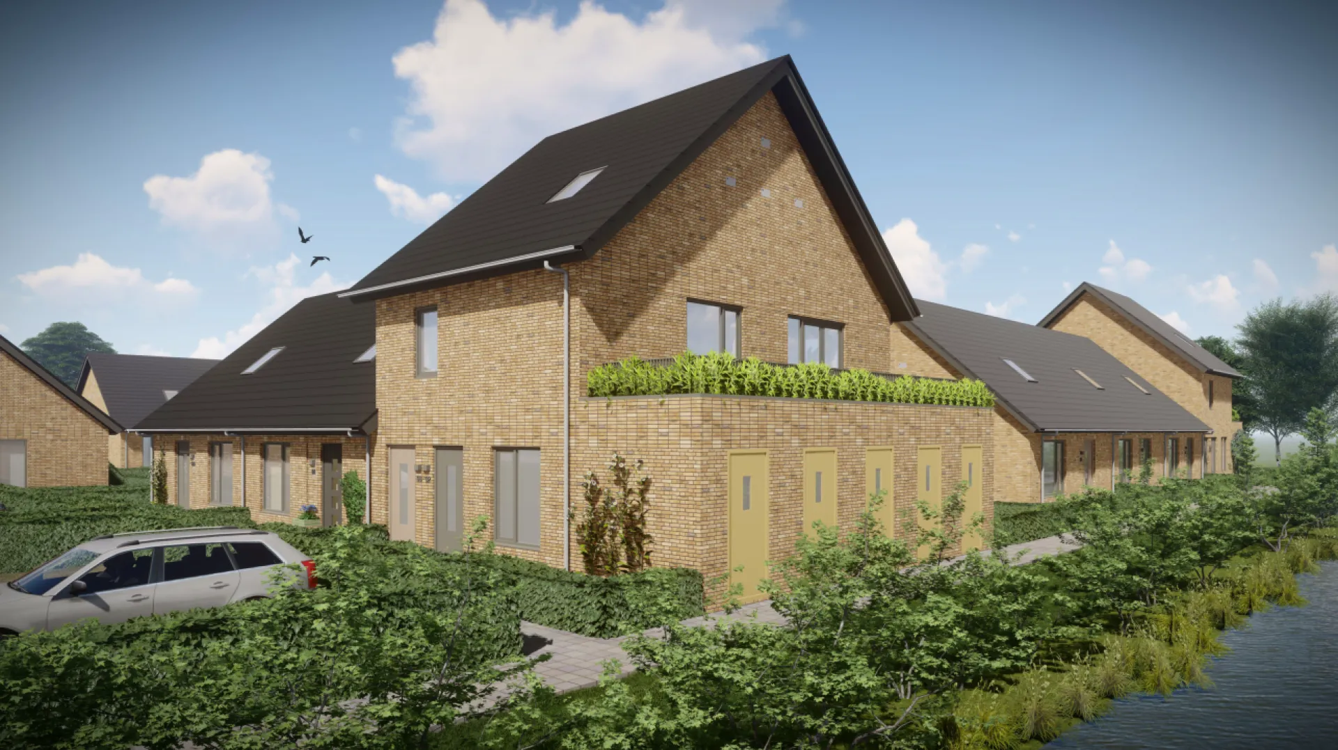 Rij van moderne bakstenen huizen met groene omheining.