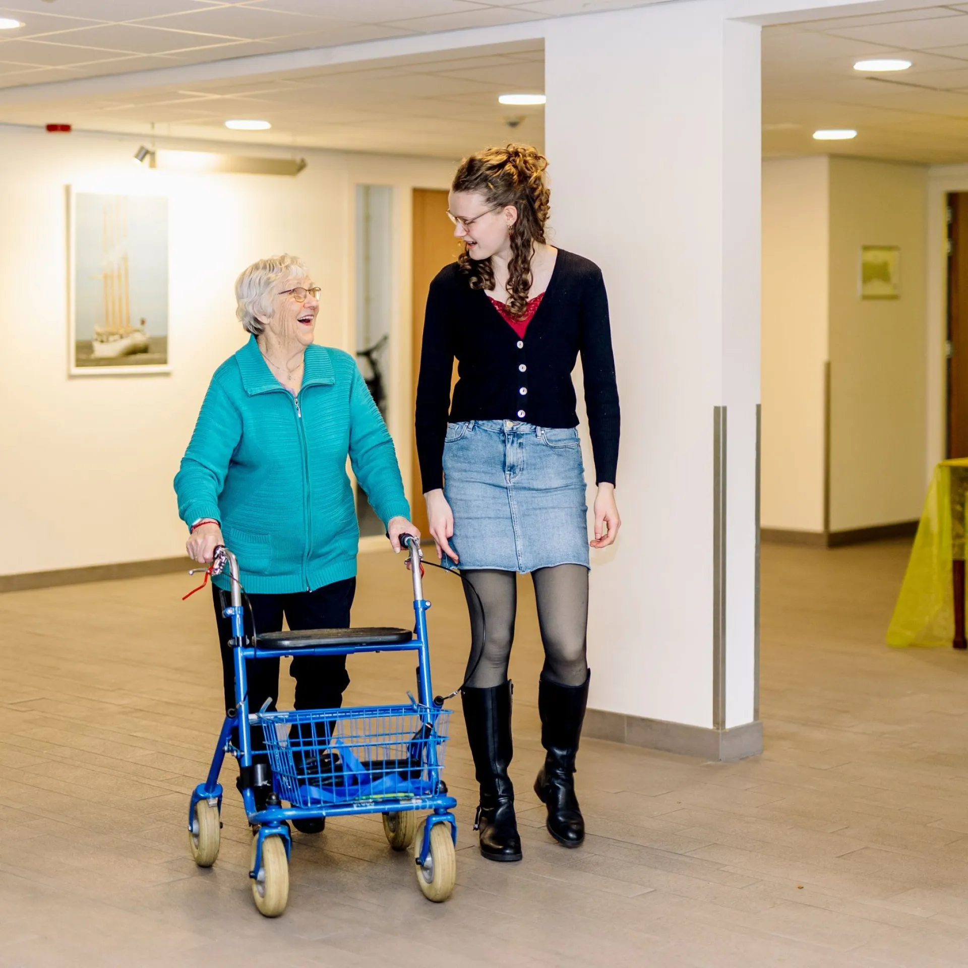 Woonstudent en oudere bewoner lopen door de gang